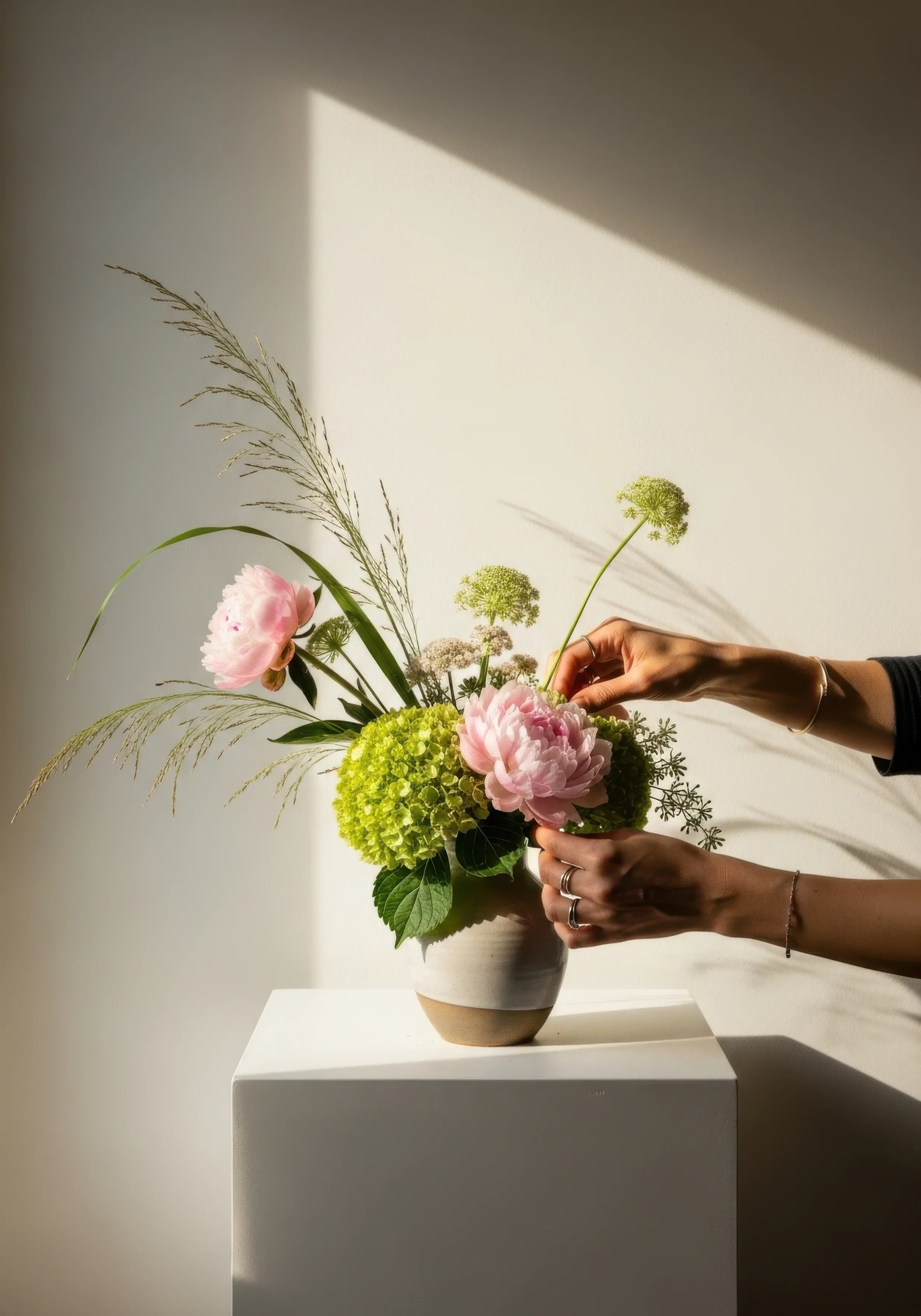 Arranging pink peonies and hydrangeas in a vase at The Urban Blooms studio
